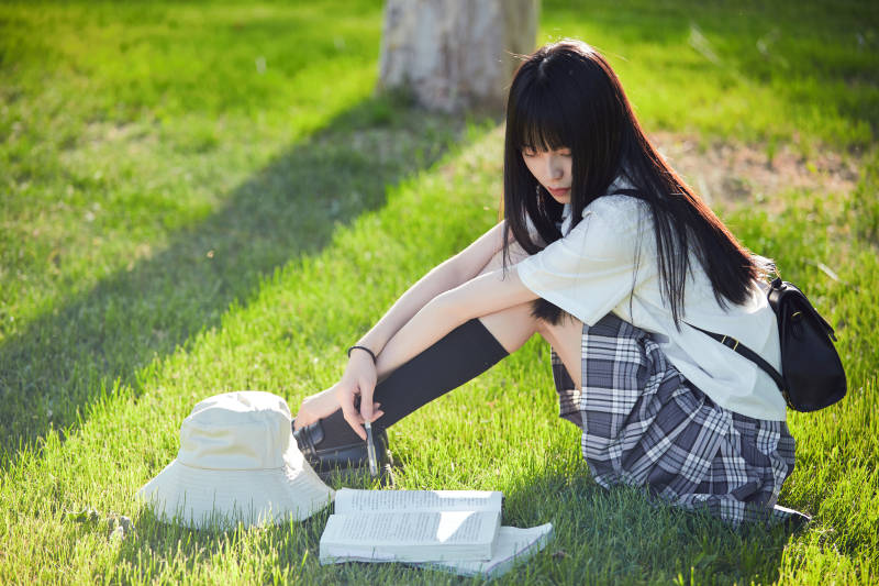 在户外草坪看书学习的女生图片