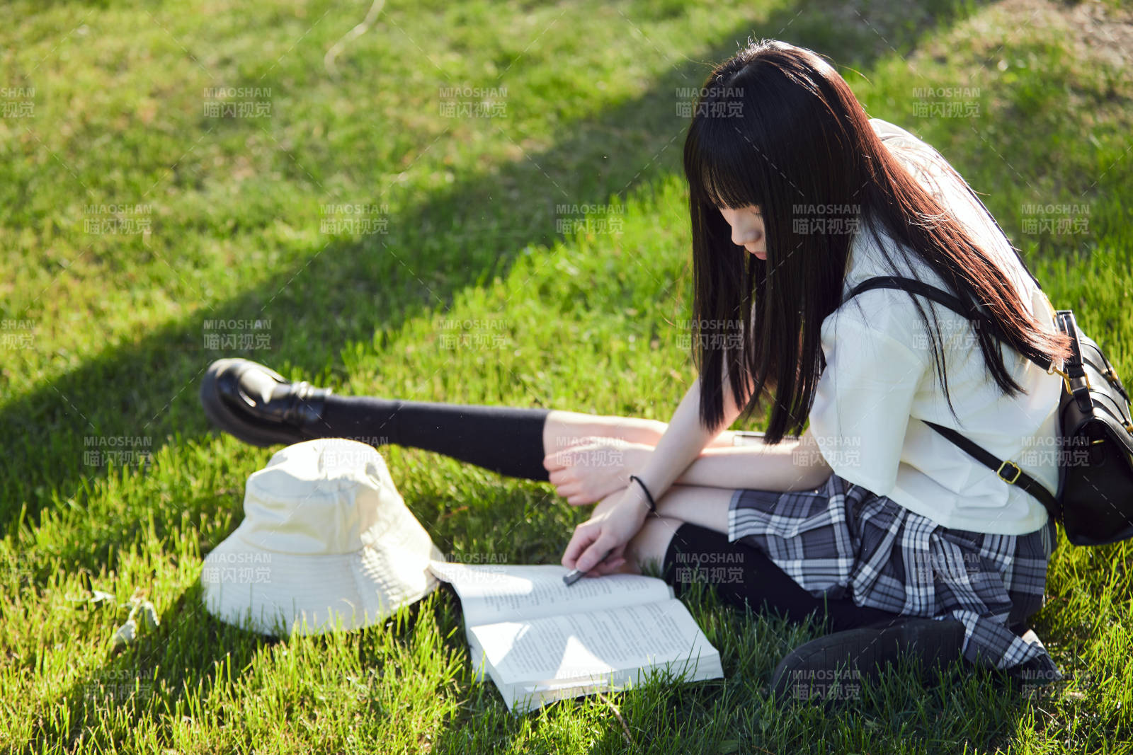 在户外草坪看书学习的女生图片