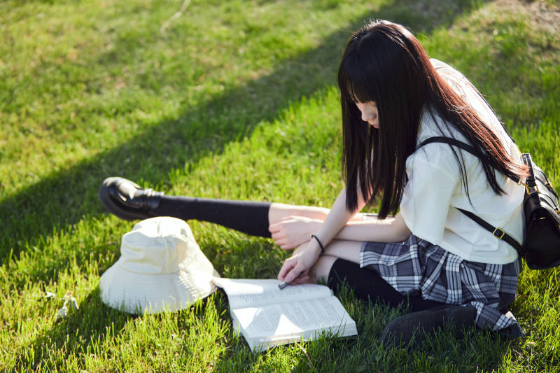 在户外草坪看书学习的女生图片