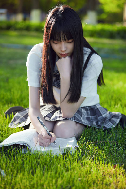 在户外草坪看书学习的女生图片