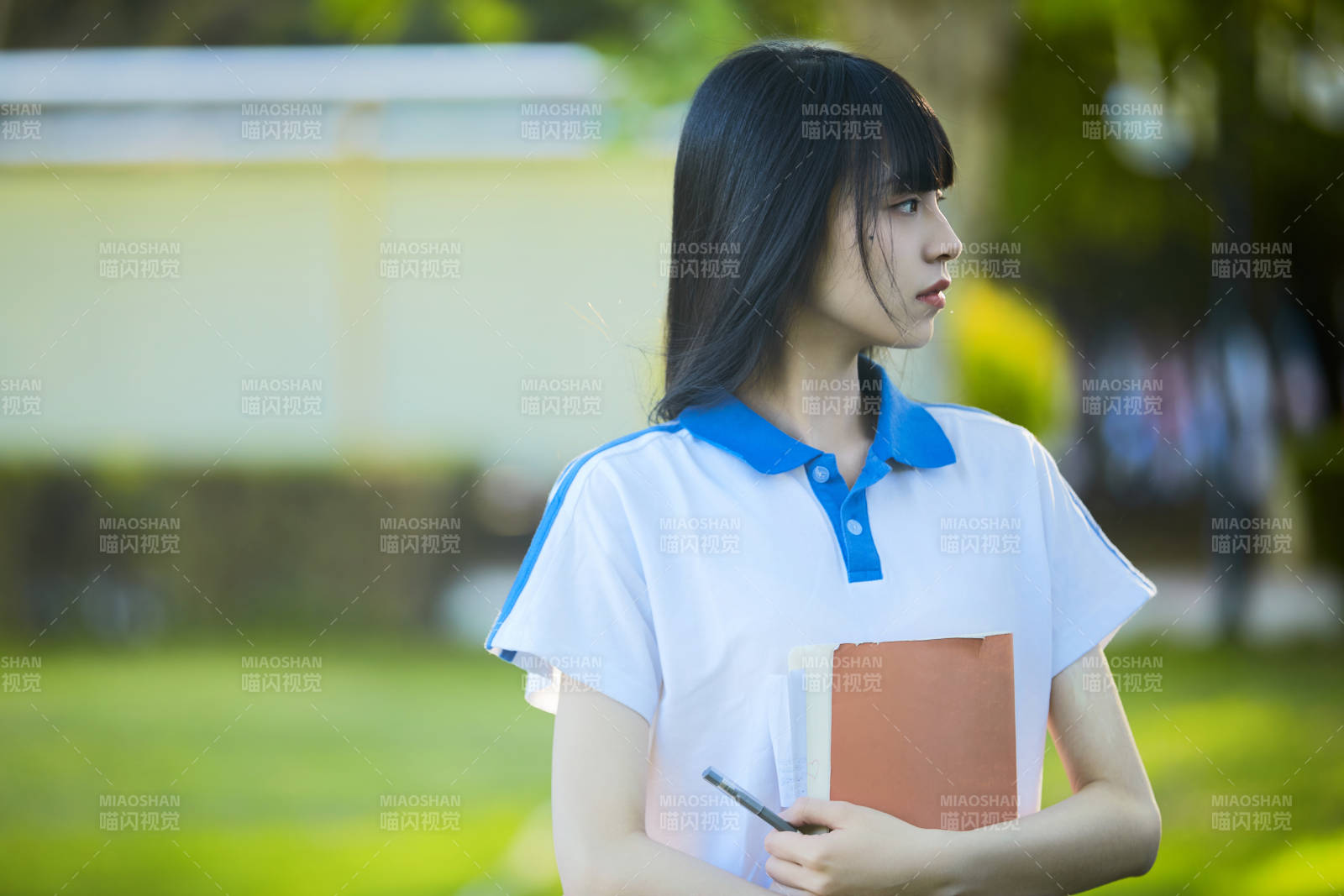 校园里抱着书的高中女生图片