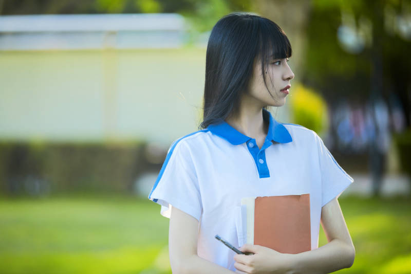 校园里抱着书的高中女生图片