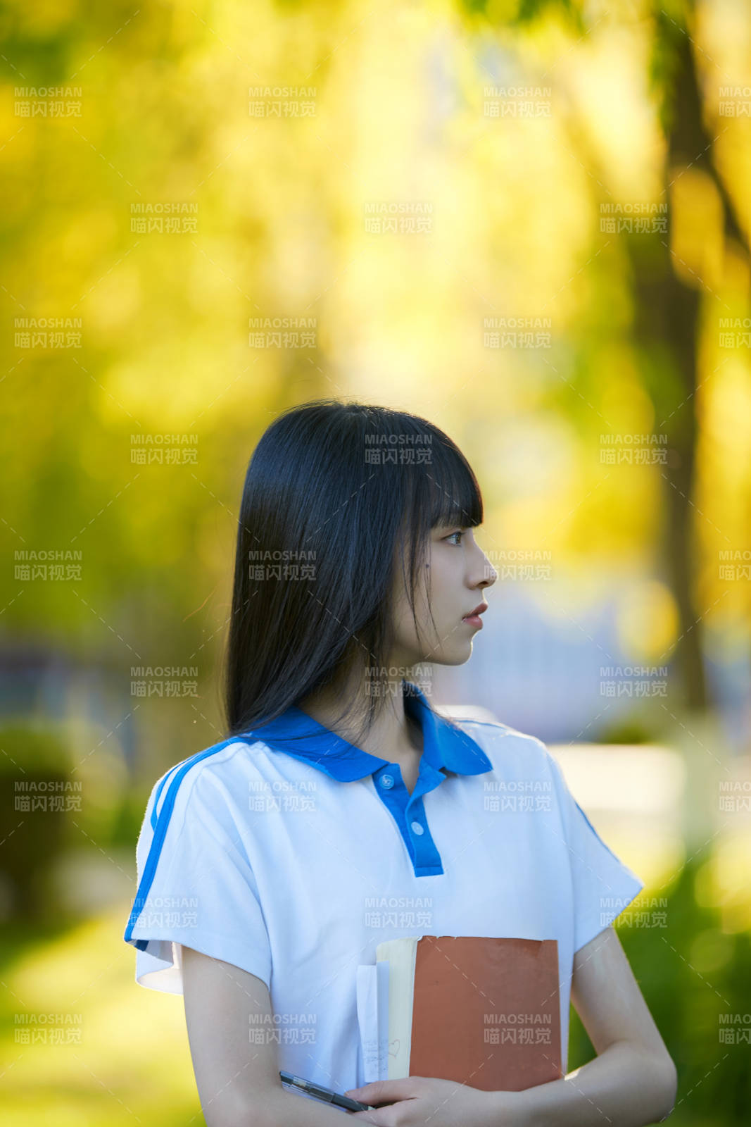 校园里抱着书的高中女生图片