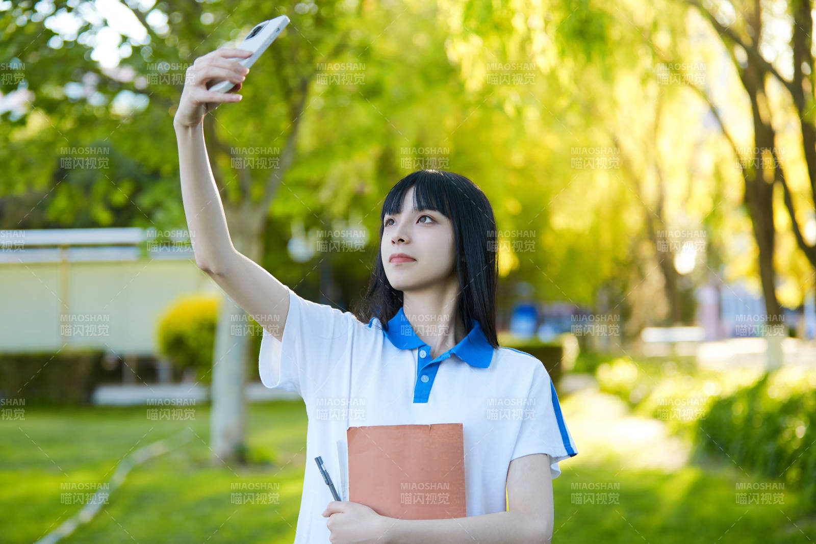 校园里用手机自拍的高中生图片