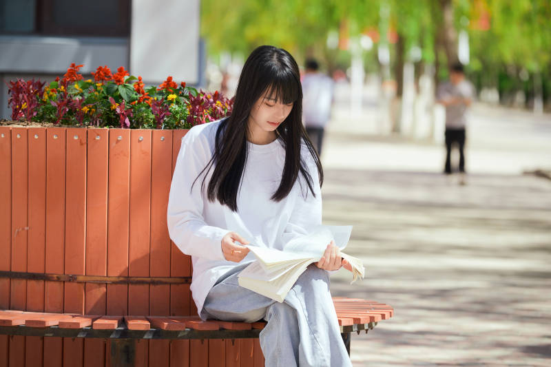 户外校园里读书学习的大学生图片