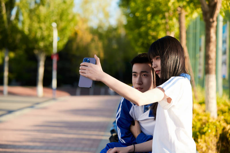 校园里用手机自拍的高中生图片