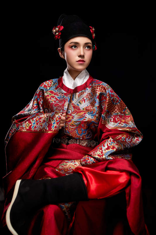 黑色背景下身着明代飞鱼服的青年女性图片