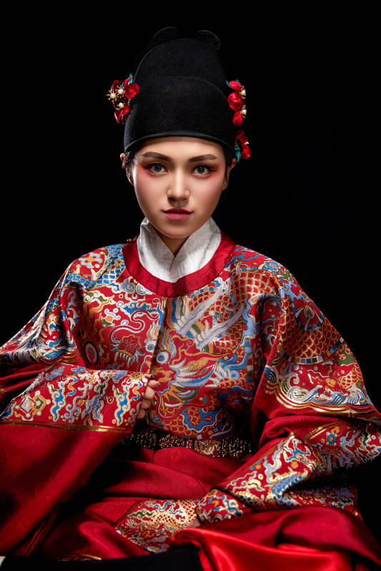 黑色背景下身着明代飞鱼服的青年女性图片