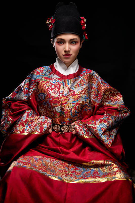 黑色背景下身着明代飞鱼服的青年女性图片