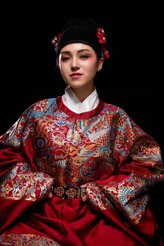 黑色背景下身着明代飞鱼服的青年女性图片