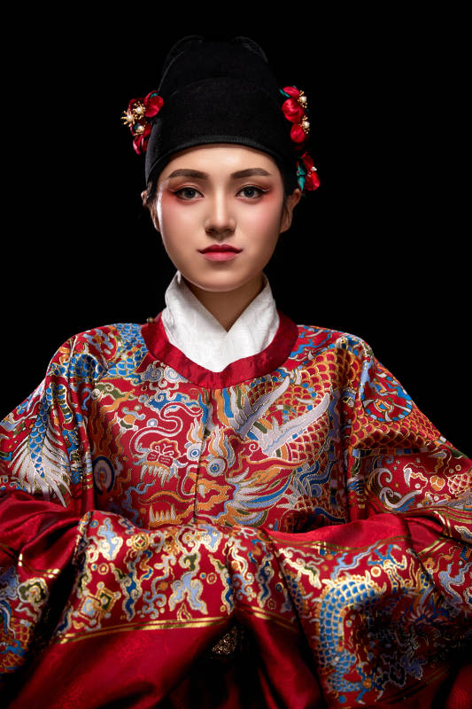 黑色背景下身着明代飞鱼服的青年女性图片