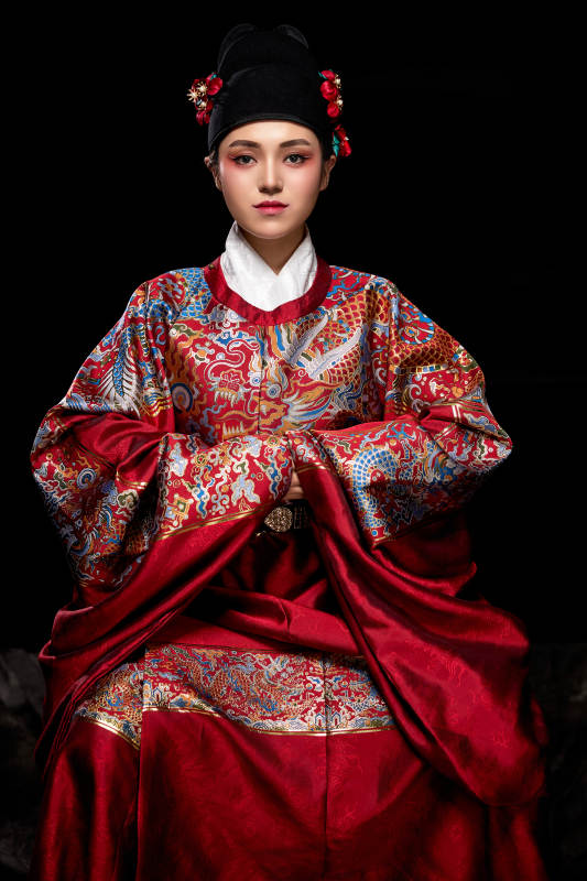 黑色背景下身着明代飞鱼服的青年女性图片