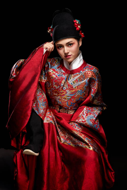 黑色背景下身着明代飞鱼服的青年女性图片