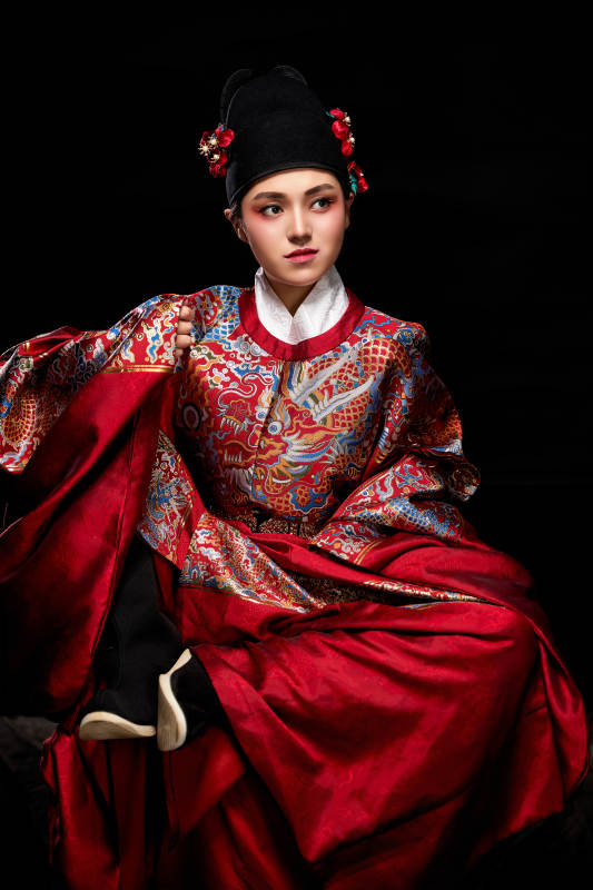 黑色背景下身着明代飞鱼服的青年女性图片