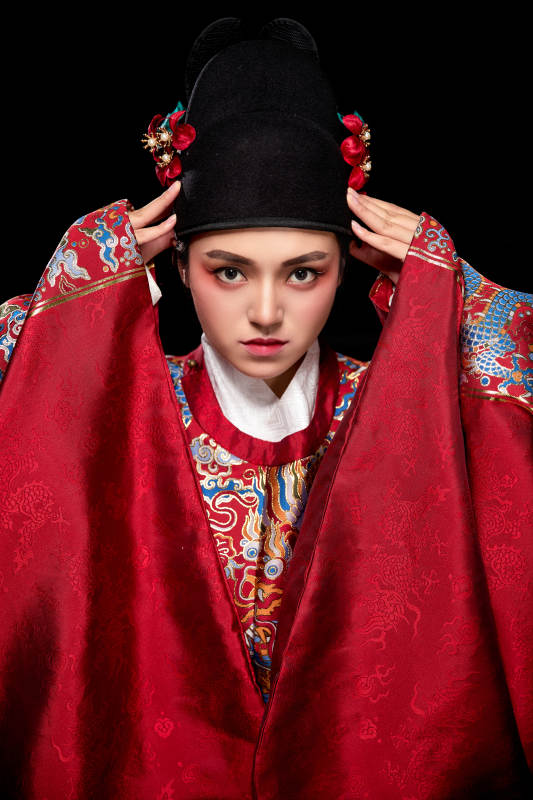 黑色背景下身着明代飞鱼服的青年女性图片