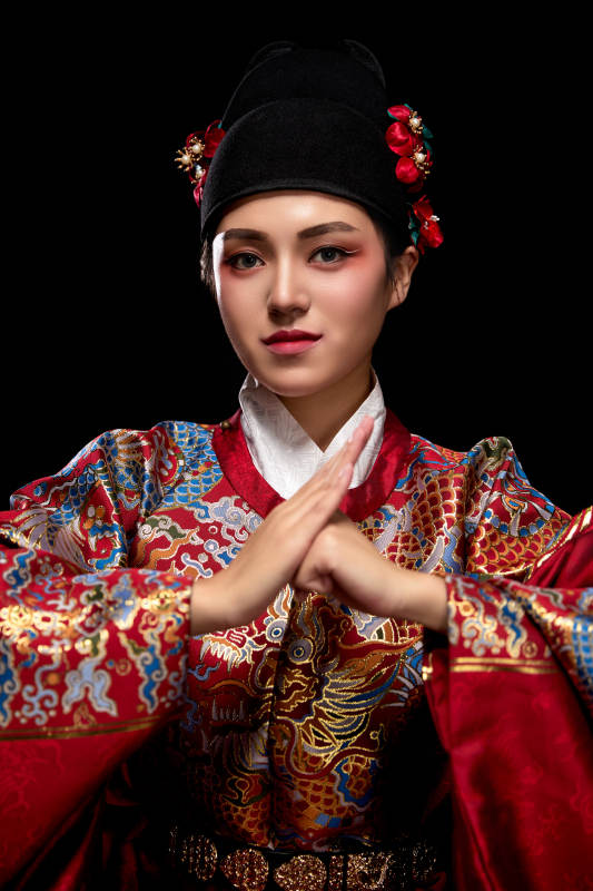 黑色背景下身着明代飞鱼服的青年女性图片