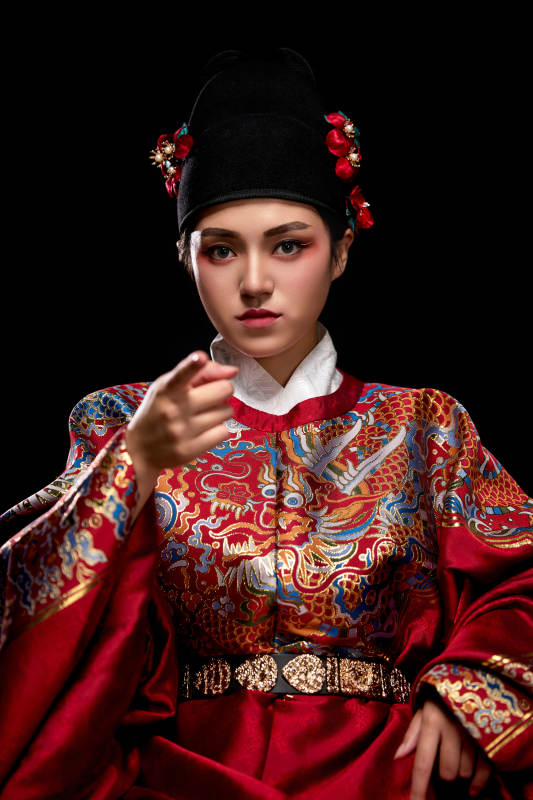 黑色背景下身着明代飞鱼服的青年女性图片