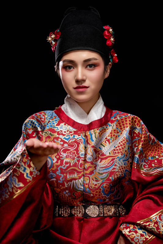 黑色背景下身着明代飞鱼服的青年女性图片