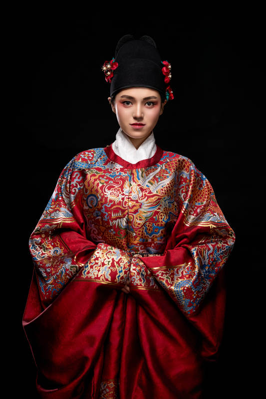黑色背景下身着明代飞鱼服的青年女性图片