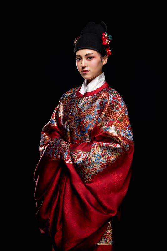 黑色背景下身着明代飞鱼服的青年女性图片
