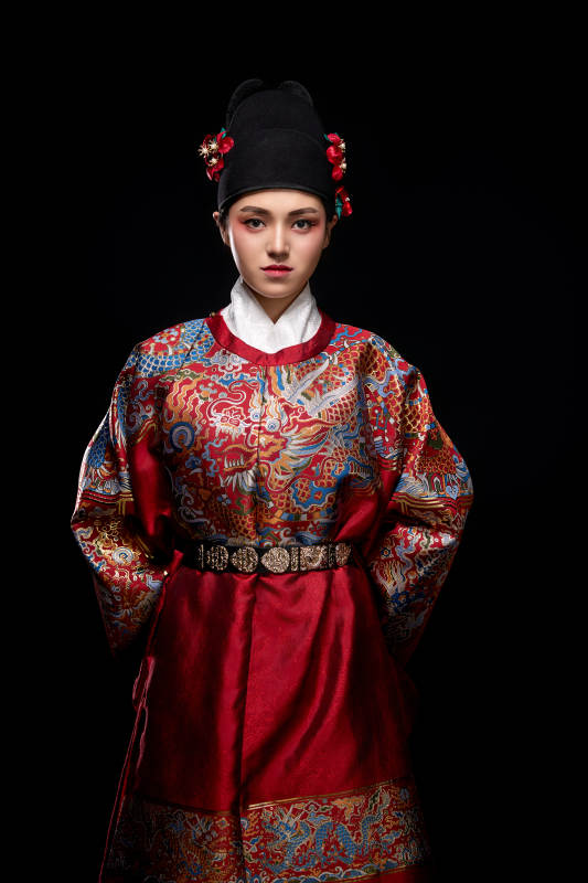 黑色背景下身着明代飞鱼服的青年女性图片