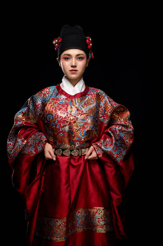 黑色背景下身着明代飞鱼服的青年女性图片
