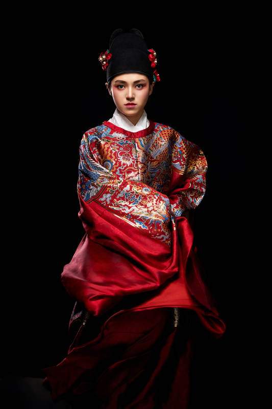 黑色背景下身着明代飞鱼服的青年女性图片