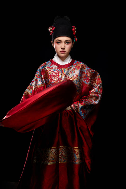 黑色背景下身着明代飞鱼服的青年女性图片