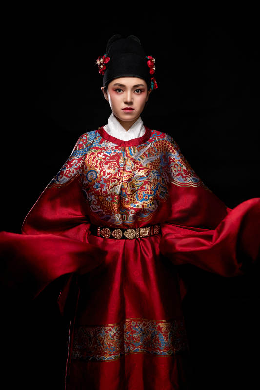 黑色背景下身着明代飞鱼服的青年女性图片