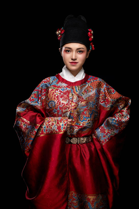 黑色背景下身着明代飞鱼服的青年女性图片