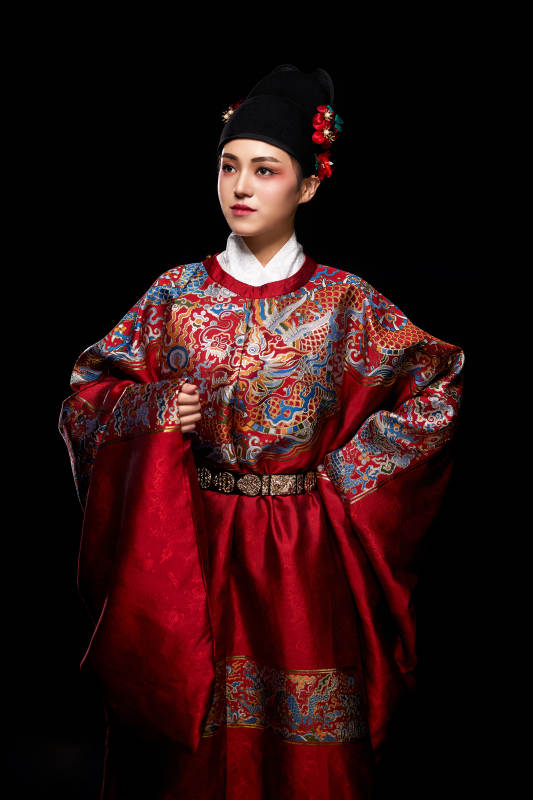 黑色背景下身着明代飞鱼服的青年女性图片