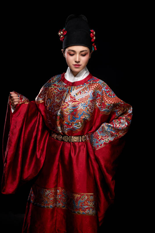 黑色背景下身着明代飞鱼服的青年女性图片