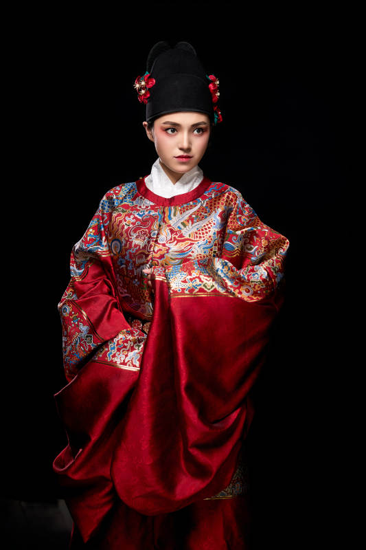 黑色背景下身着明代飞鱼服的青年女性图片