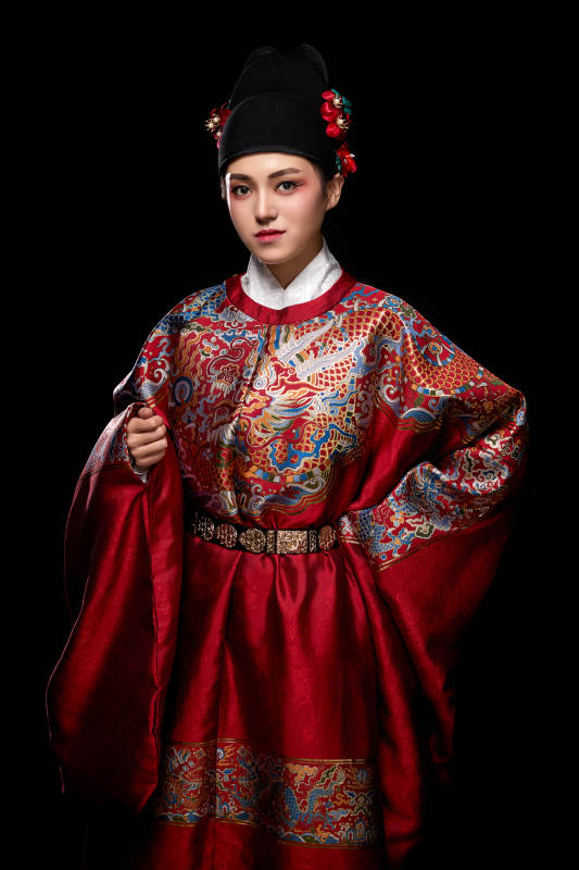 黑色背景下身着明代飞鱼服的青年女性图片