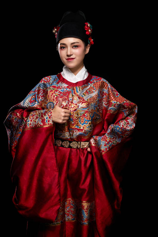 黑色背景下身着明代飞鱼服的青年女性图片