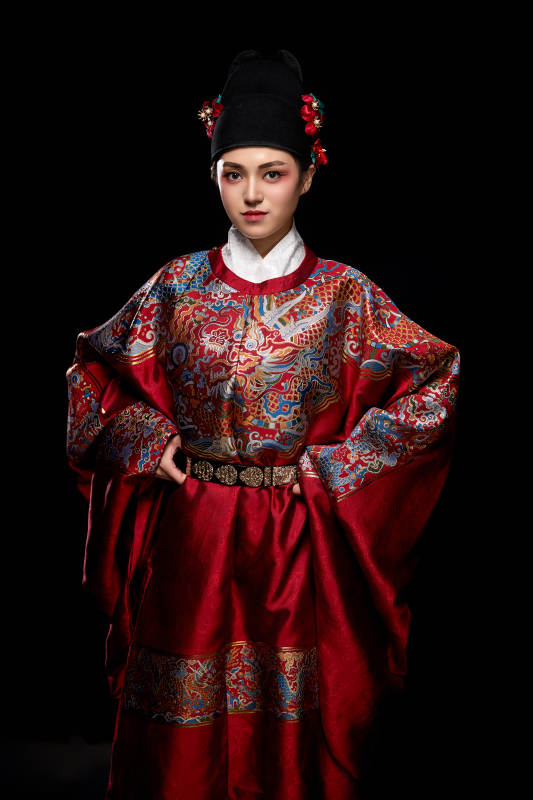 黑色背景下身着明代飞鱼服的青年女性图片