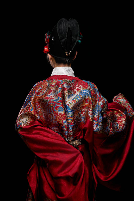 黑色背景下身着明代飞鱼服的青年女性图片