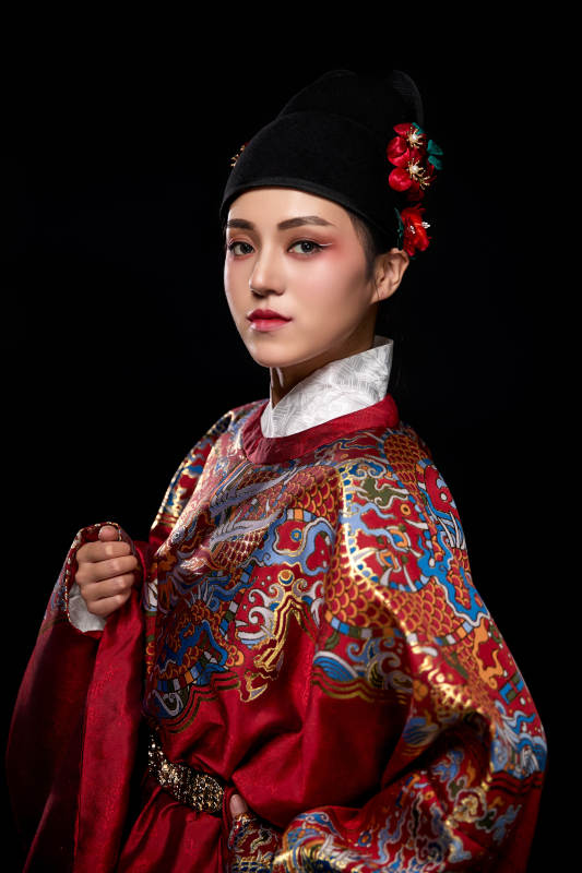 黑色背景下身着明代飞鱼服的青年女性图片