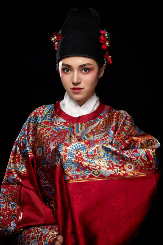 黑色背景下身着明代飞鱼服的青年女性图片
