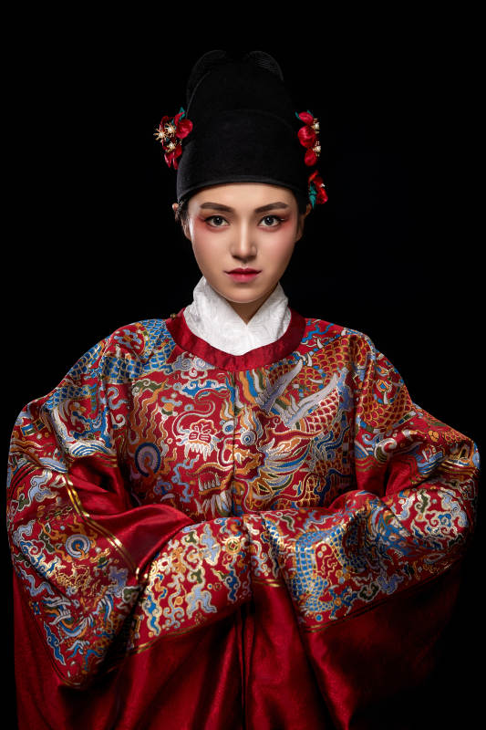 黑色背景下身着明代飞鱼服的青年女性图片