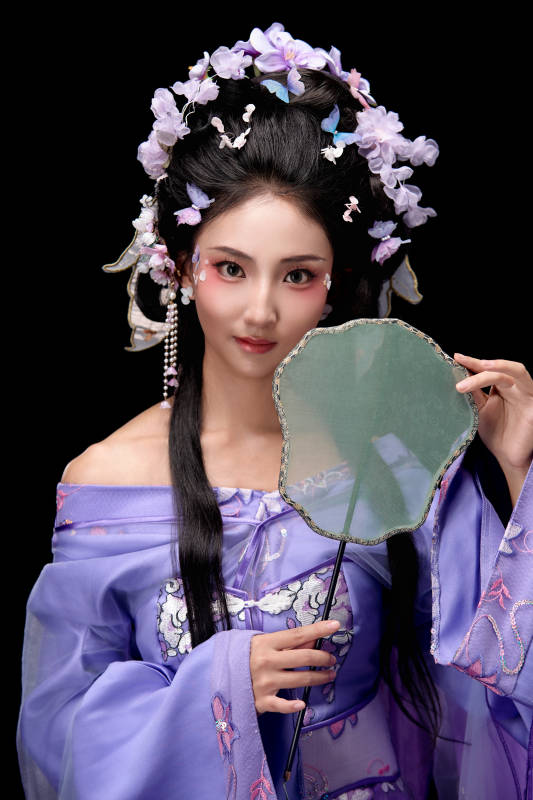 身着簪花仕女装扮手持轻扇的东方女性图片