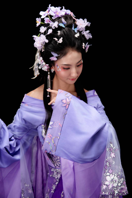 身着簪花仕女装扮手持轻扇的东方女性图片