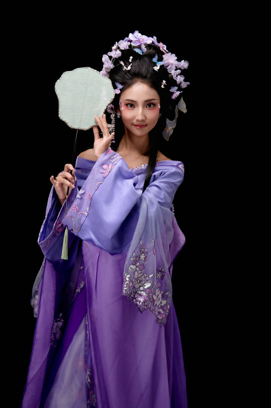 身着簪花仕女装扮手持轻扇的东方女性图片