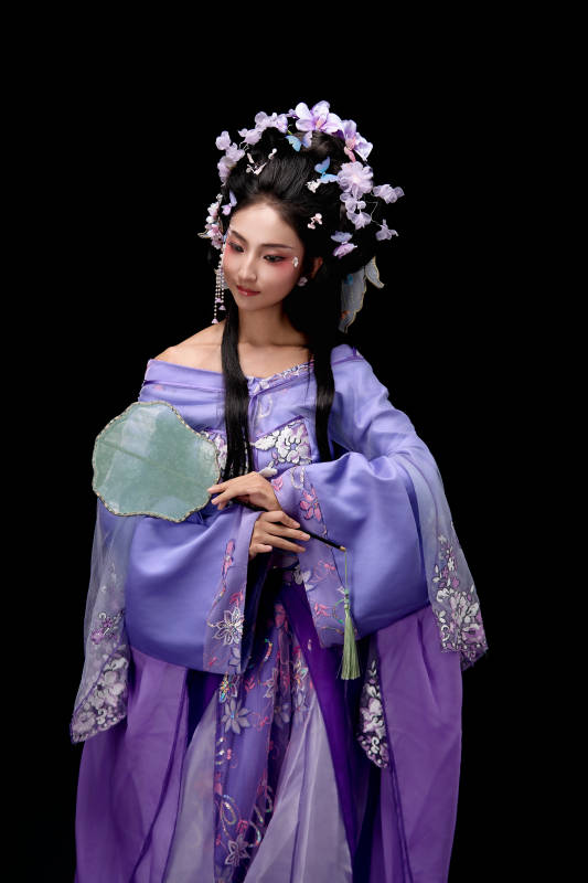 身着簪花仕女装扮手持轻扇的东方女性图片