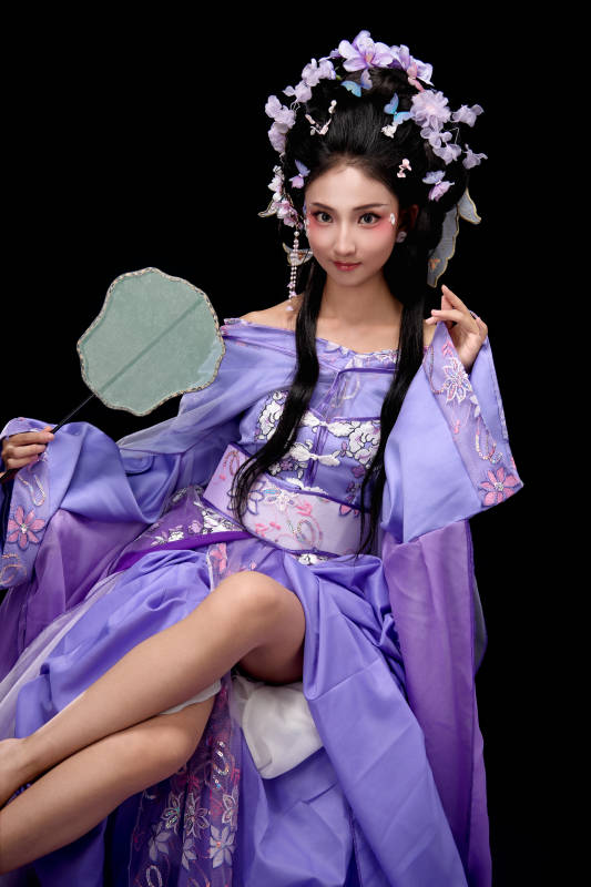 身着簪花仕女装扮坐在木桌上的东方女性图片