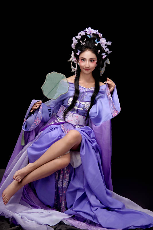 身着簪花仕女装扮坐在木桌上的东方女性图片