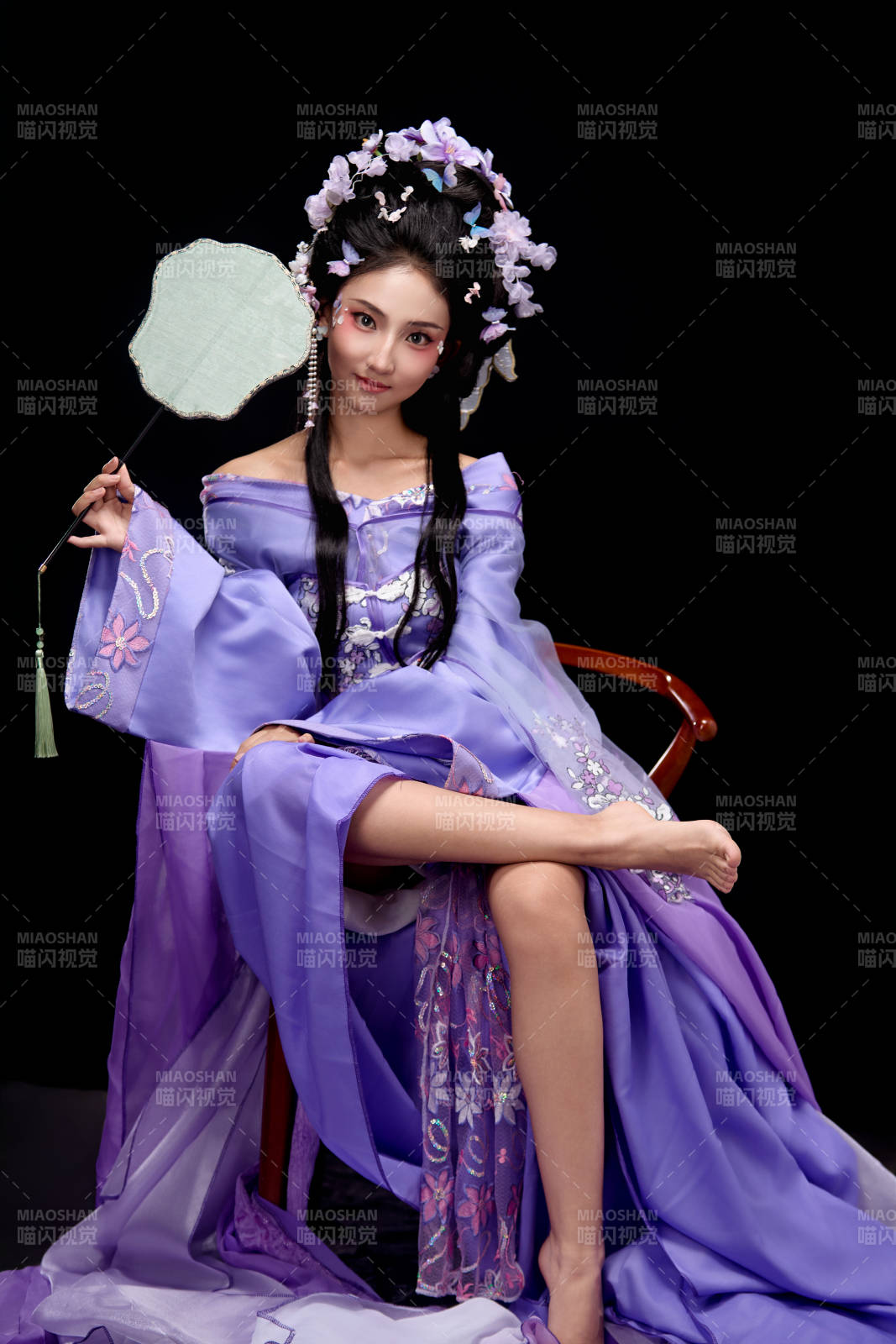 身着簪花仕女装扮坐在木桌上的东方女性图片