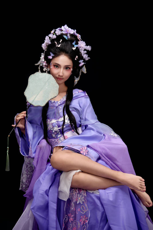 身着簪花仕女装扮坐在木桌上的东方女性图片