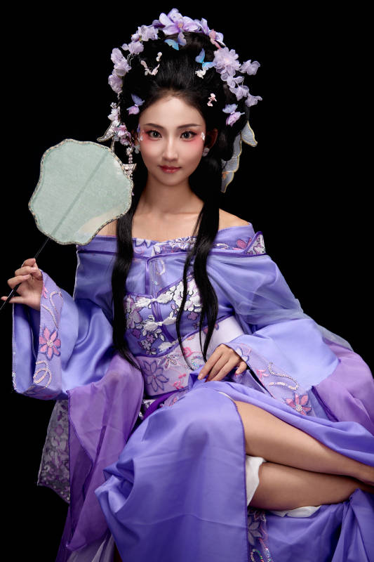 身着簪花仕女装扮坐在木桌上的东方女性图片