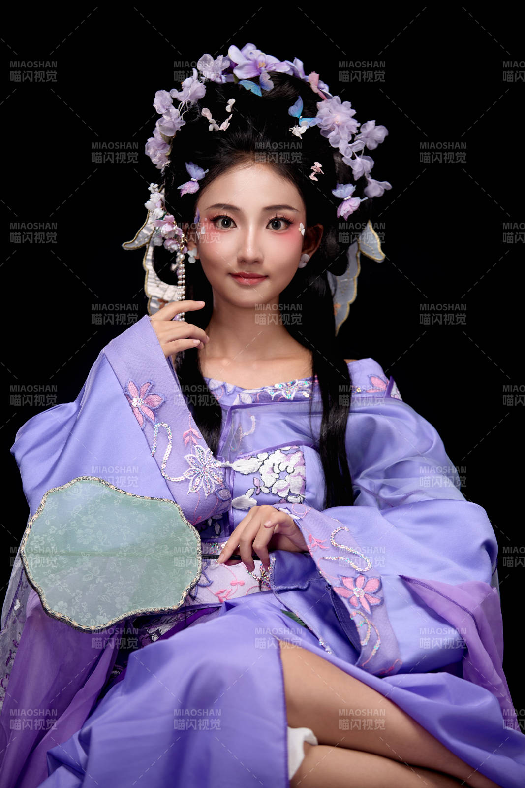 身着簪花仕女装扮坐在木桌上的东方女性图片